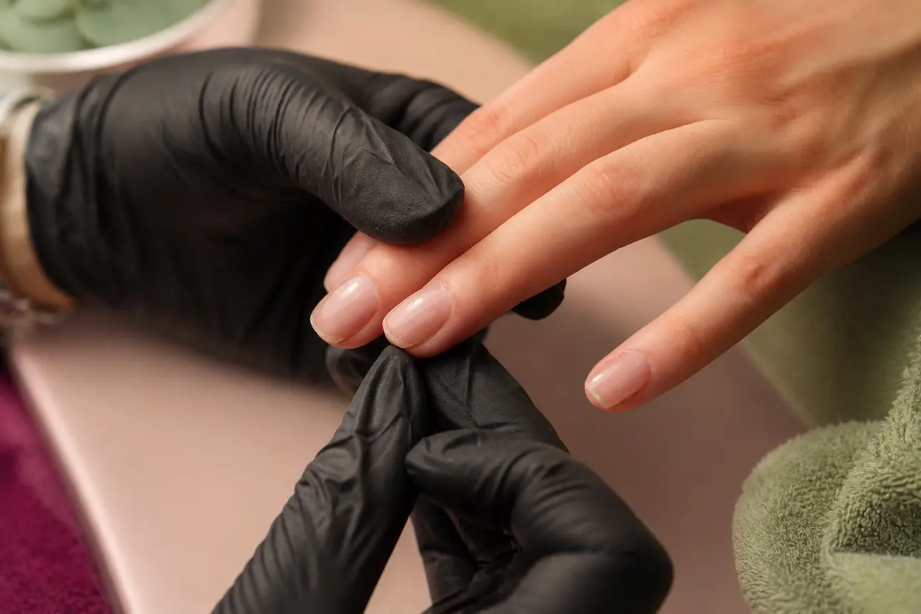 Handpflege mit schwarzen Handschuhen